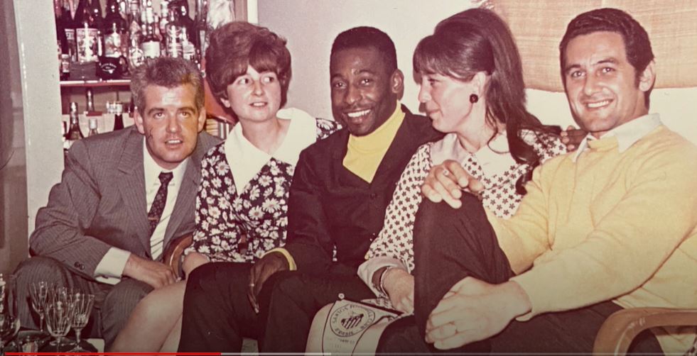 gruppe von 2 Männern und 2 Frauen auf dem Sofa mit Pelé in der Mitte