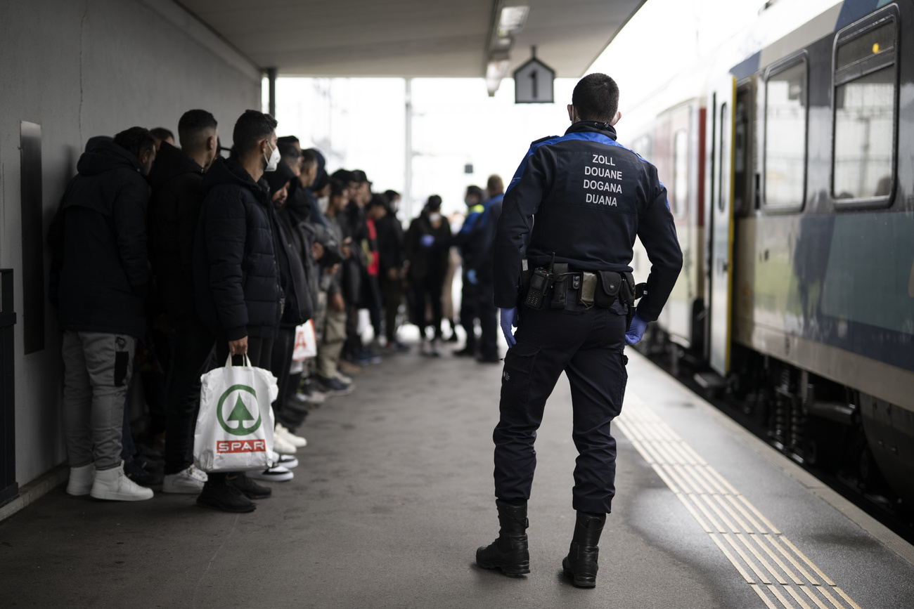 Policías y migrantes en anden de tren.