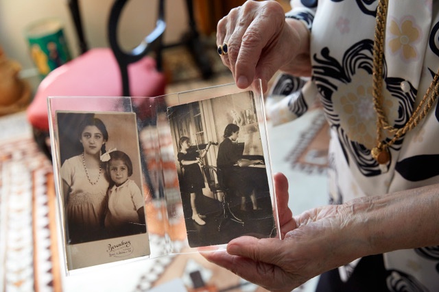 una donna mostra due fotografia con delle ragazze