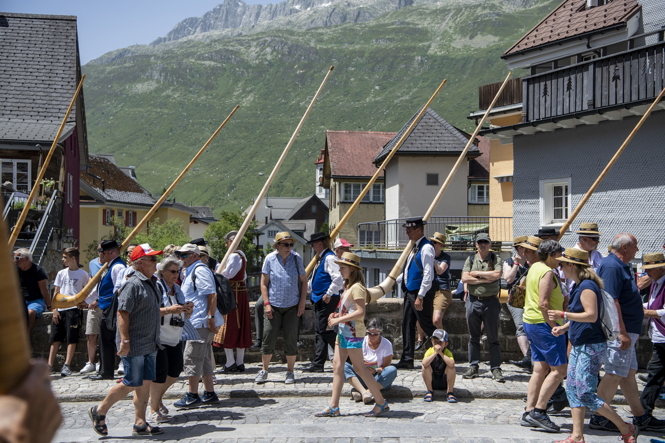 瑞士中部安德马特街上的游客和阿尔卑斯长号演奏者。