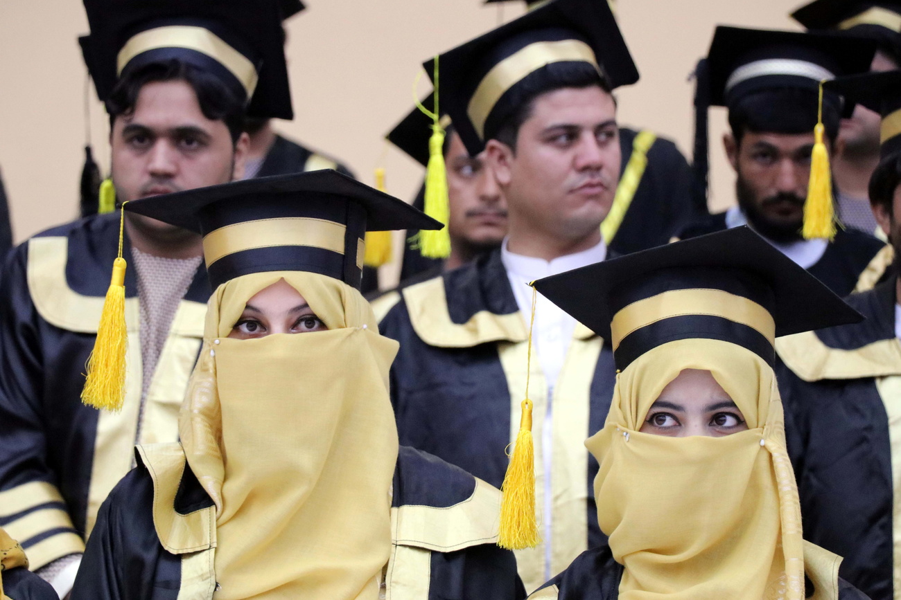 Estudiantes (hombres y mujeres) afganos en ceremonia de graduaciación, con toga y birrete.