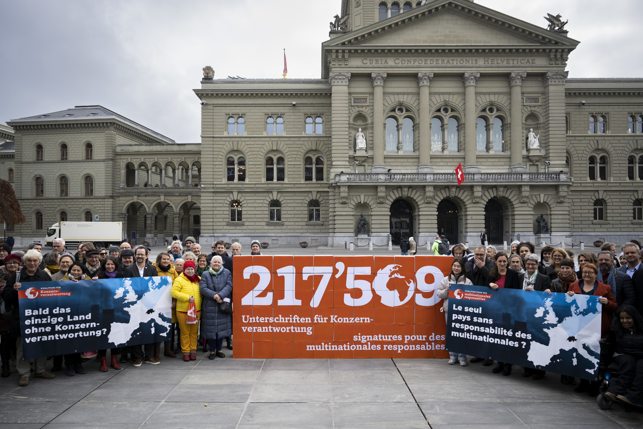 militants et militantes devant le Parlement avec une banderole