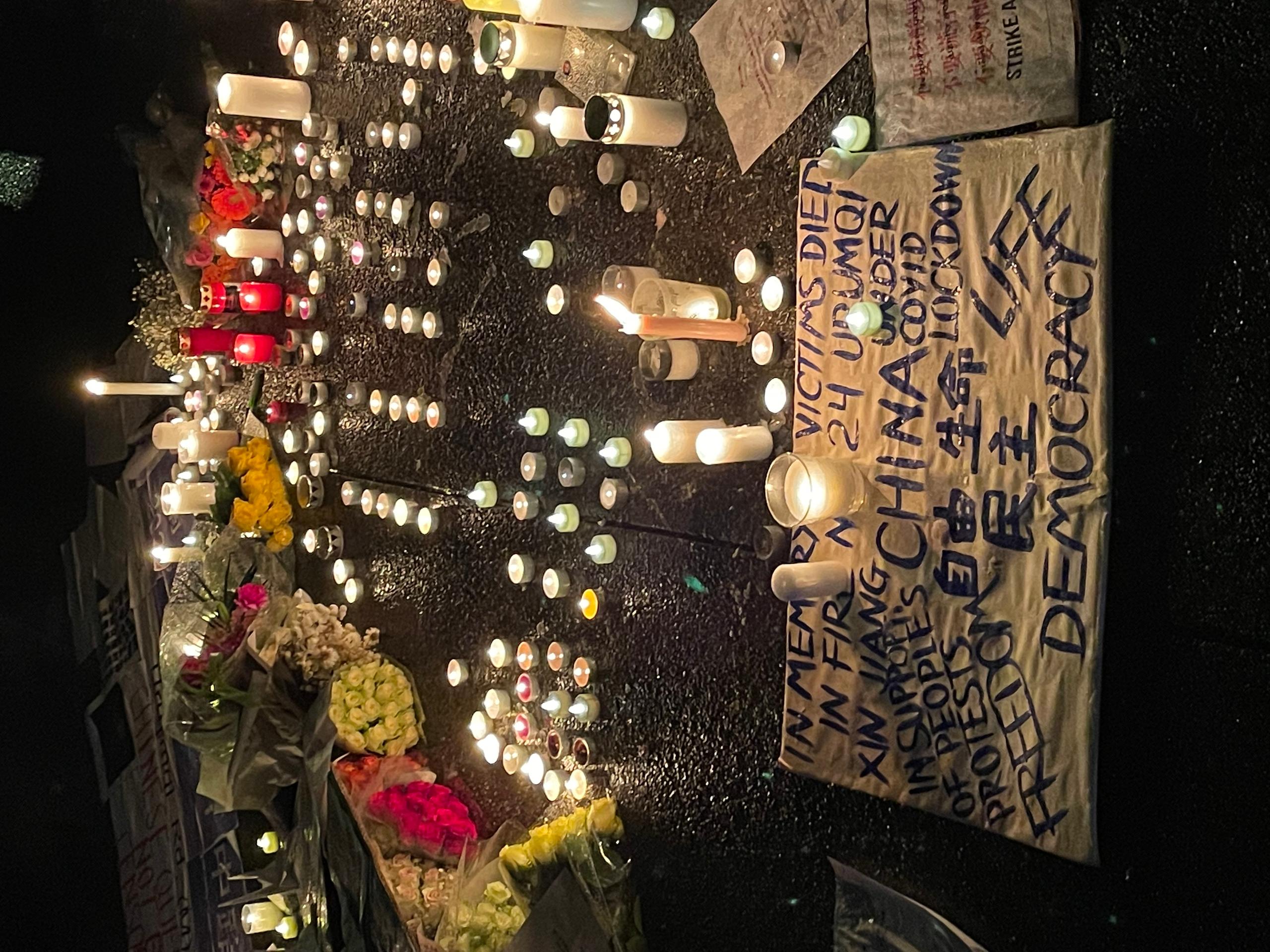 Candles and posters on the ground at vigil in Zurich