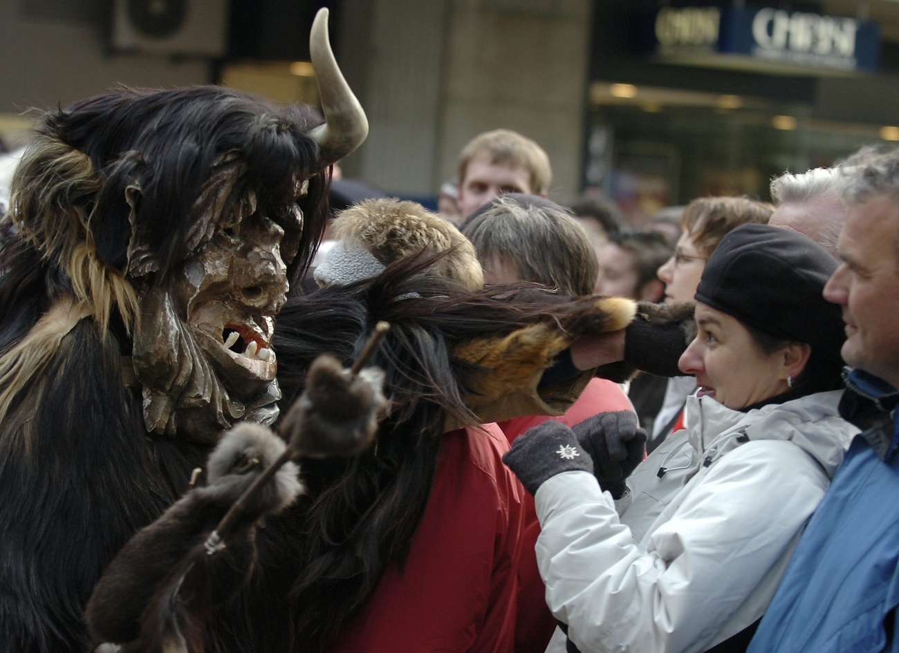 Masked person acting out a traditional Swiss custom, shocks a member of the public.