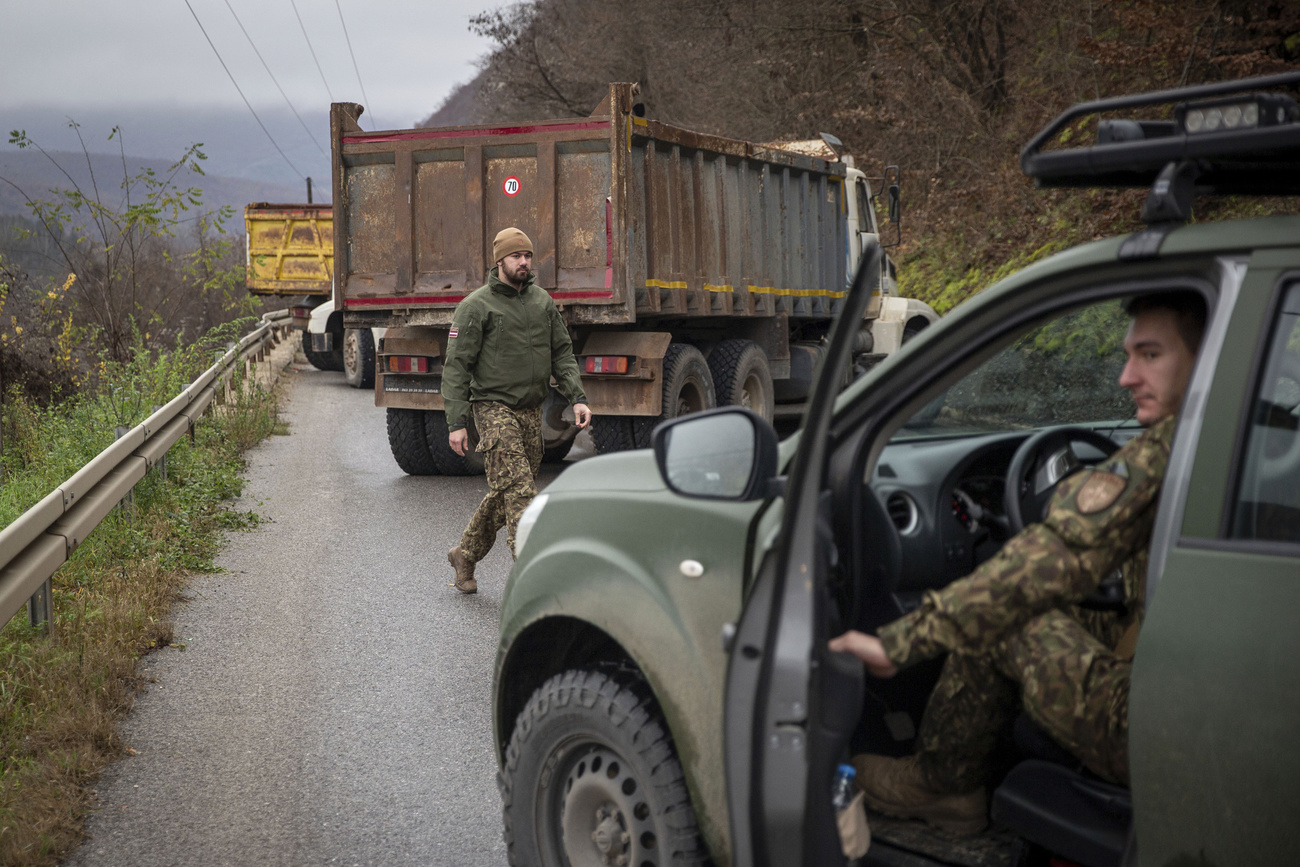 NATO forces watch over a road block in northern Kosovo