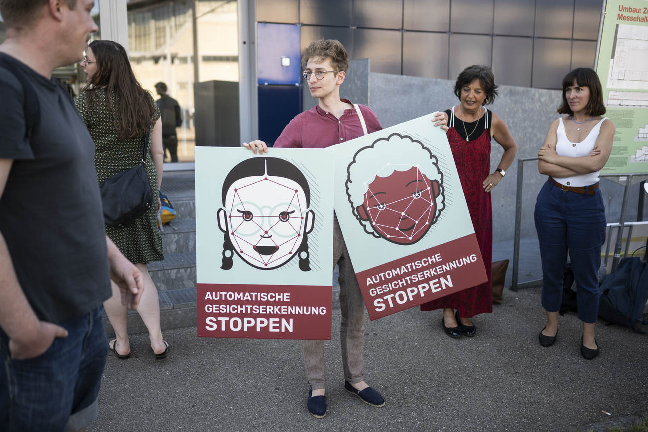 A man holding posters against facial recognition surveillance in Zurich.