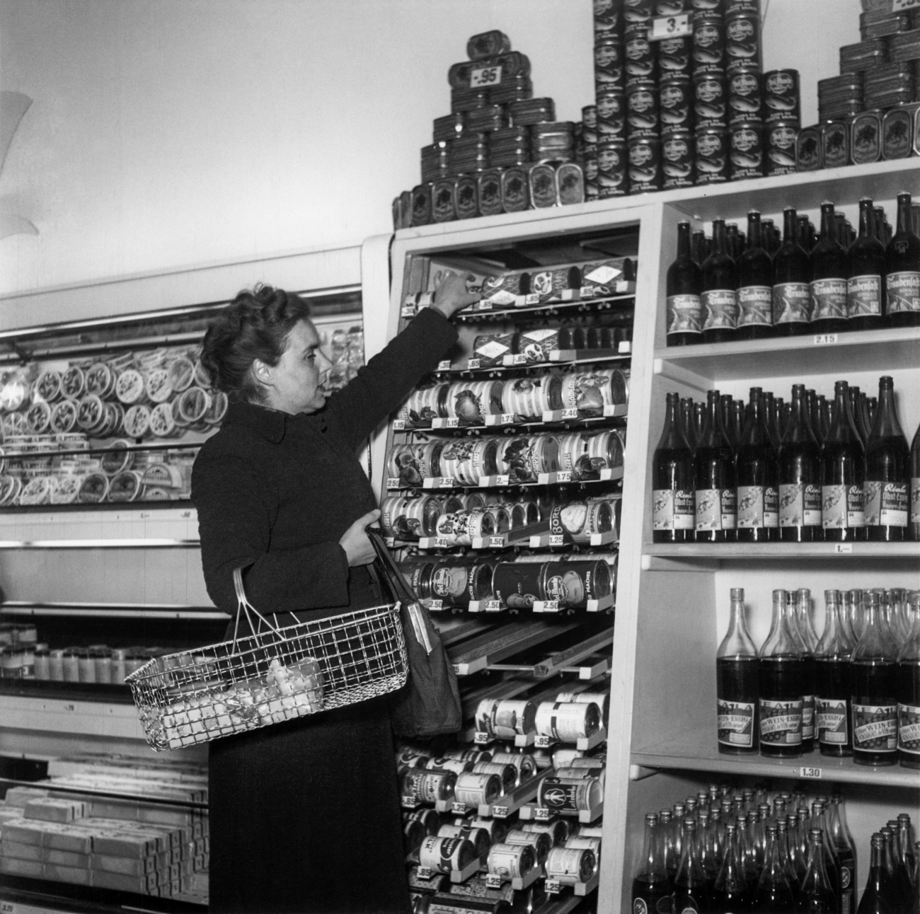 Una mujer cogiendo un producto de un estante de una tienda en 1948