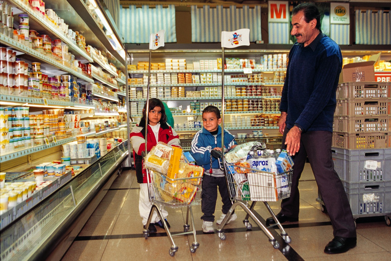 Padre con dos hijos haciendo la compra en Migros en 2002