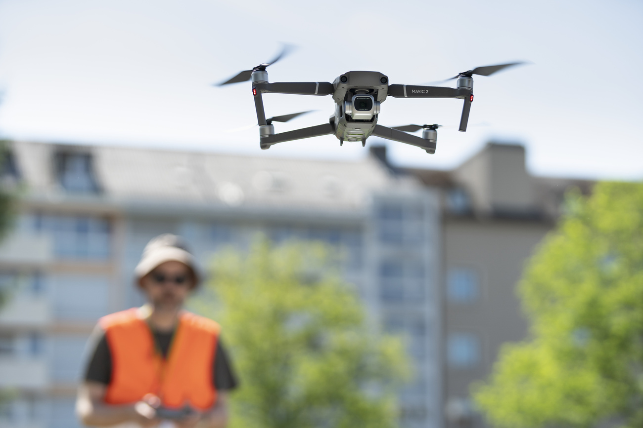 uomo in gilet arancione di sicurezza pilota drone che si vede in primo piano