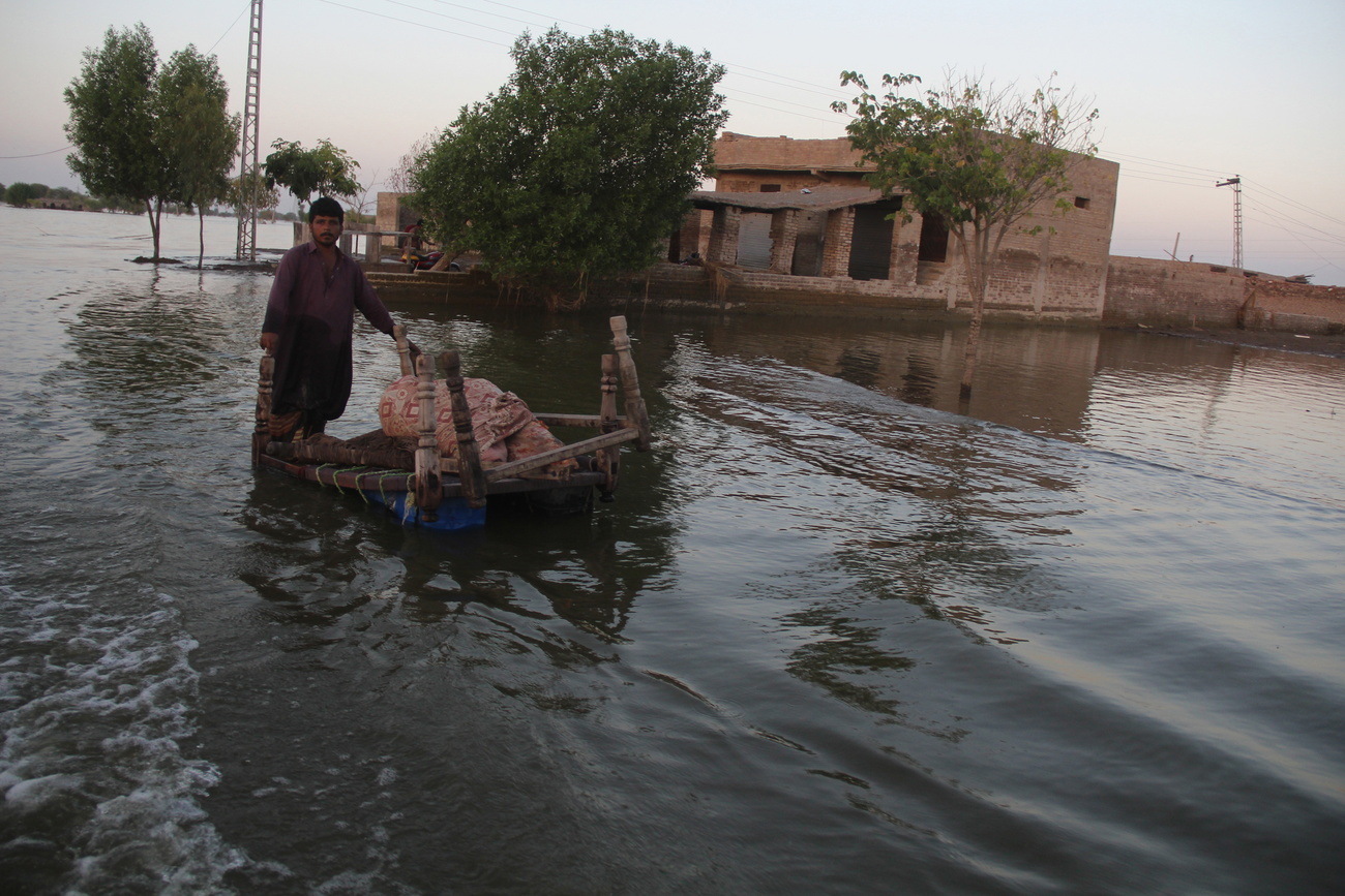 رجل يقف في مياه الفيضانات في باكستان