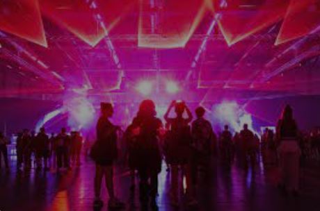 Raver:innen an einer Party in violettem Licht
