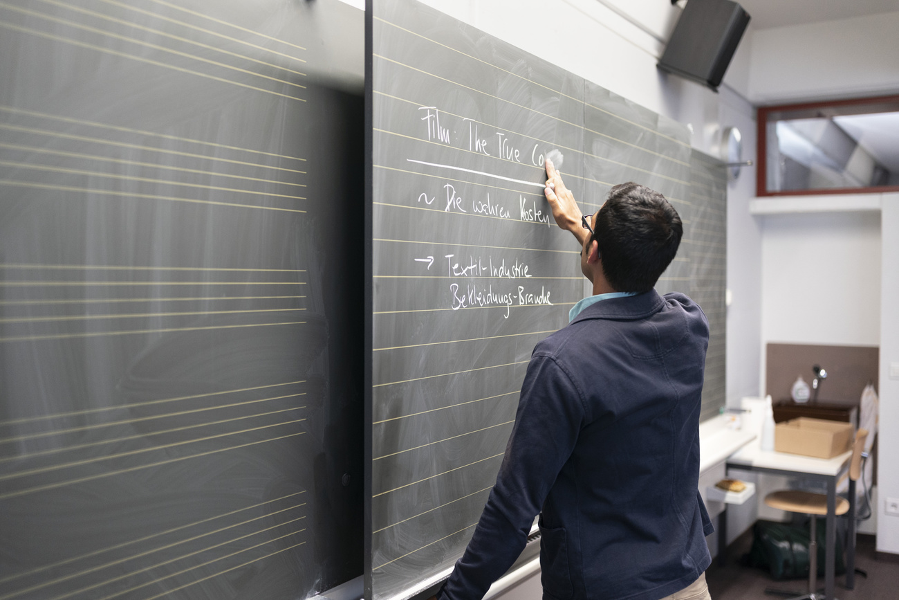 insegnante uomo scrive alla lavagna