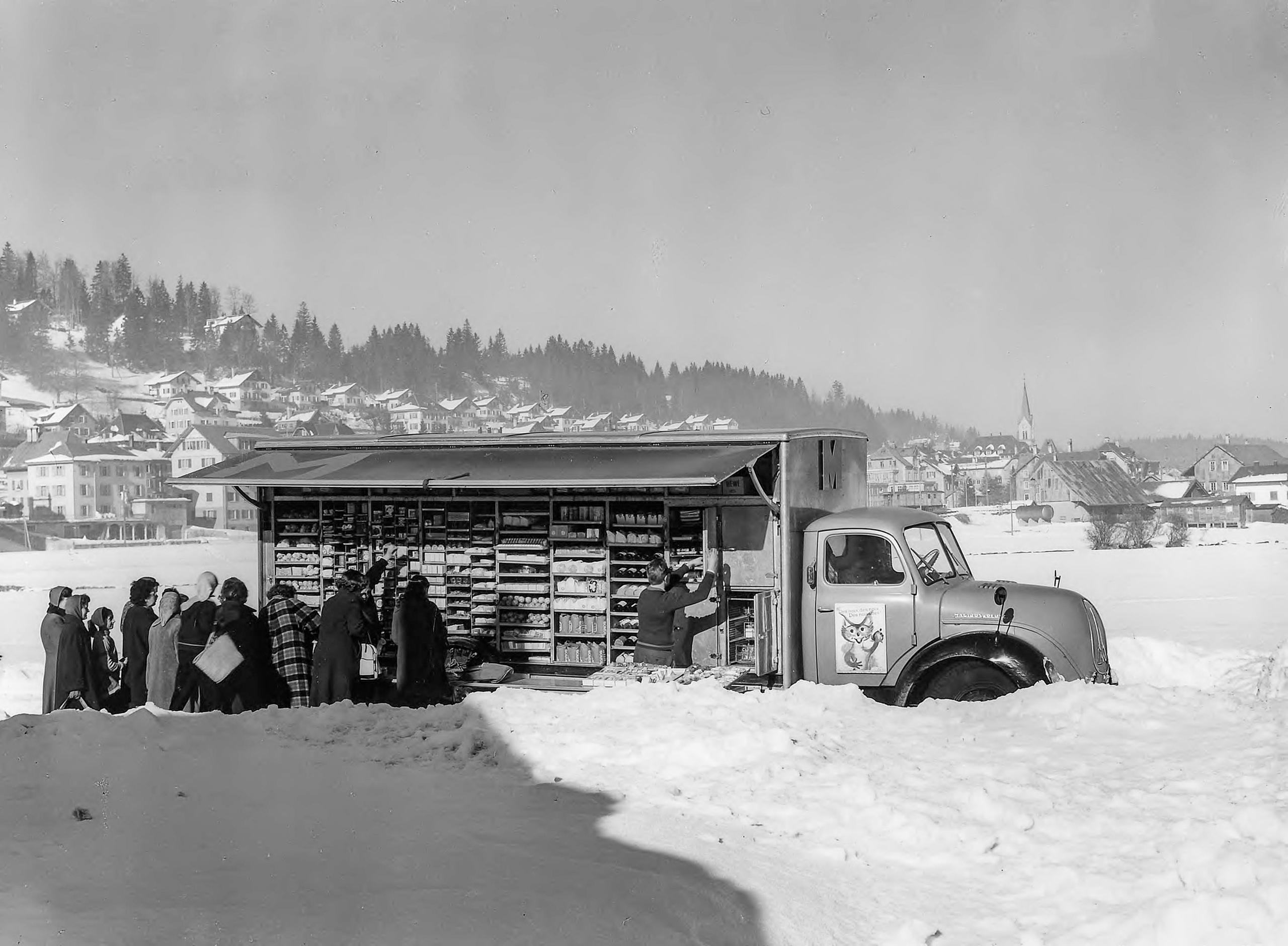 Furgoneta de ventas de Migros rodeada de nieve en 1958