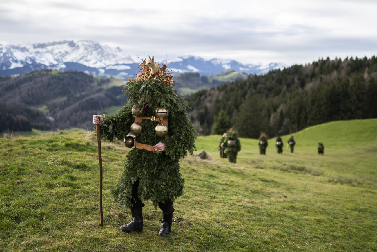 Hommes déguisés avec des branches en train de marcher