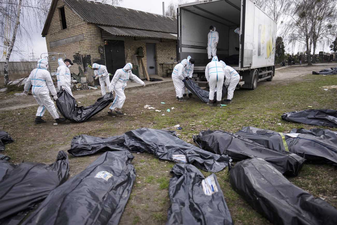 Freiwillige laden Leichen von Zivilpersonen auf einen Lastwagen