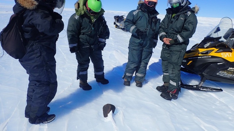 Scientists looking at a meteorite