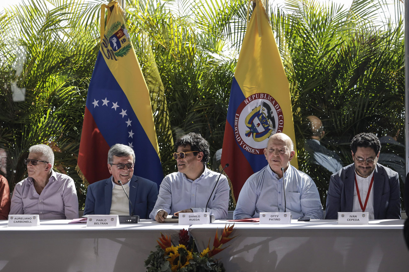 خمسة رجال يعقدون مؤتمرًا صحفيًا وفي الخلفية علما كولومبيا وفينيزويلا