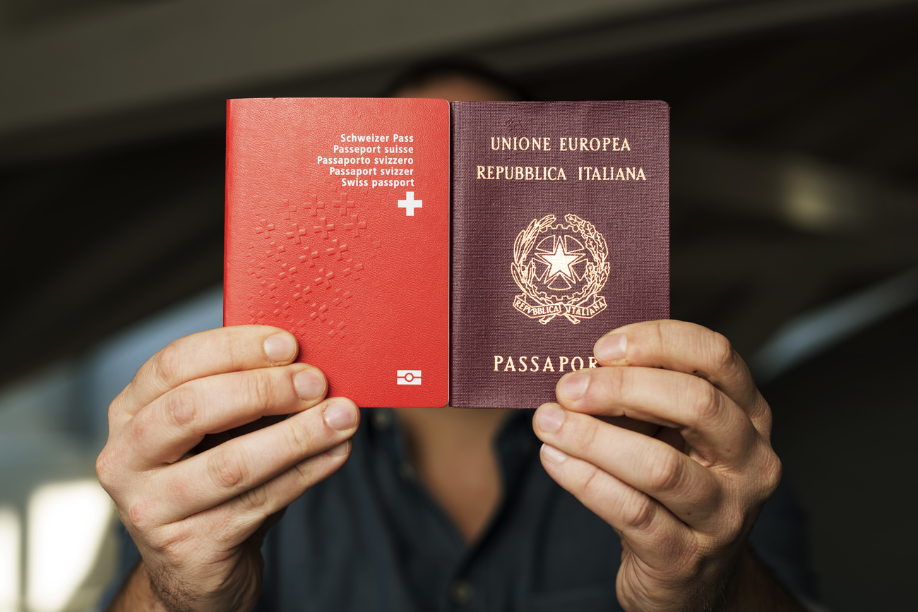 Person holding Swiss and Italian passports
