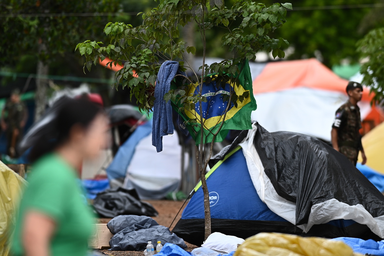 accampamento con persona in primo piano e militare sullo sfondo