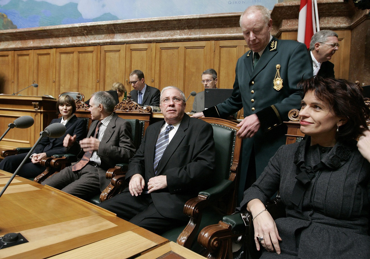 Des membres du gouvernement suisse assis dans la salle du Conseil national