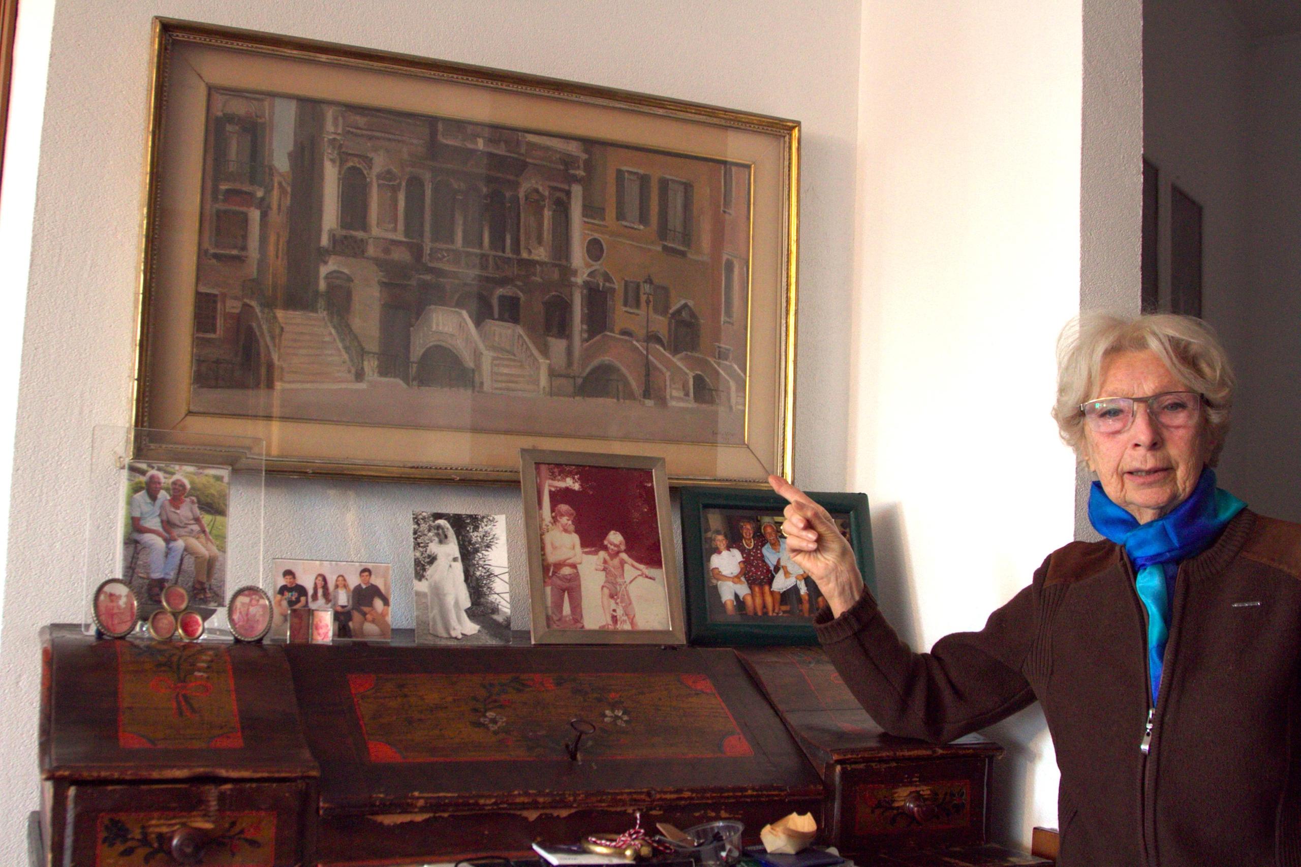 donna mostra dipinto appeso a una parete