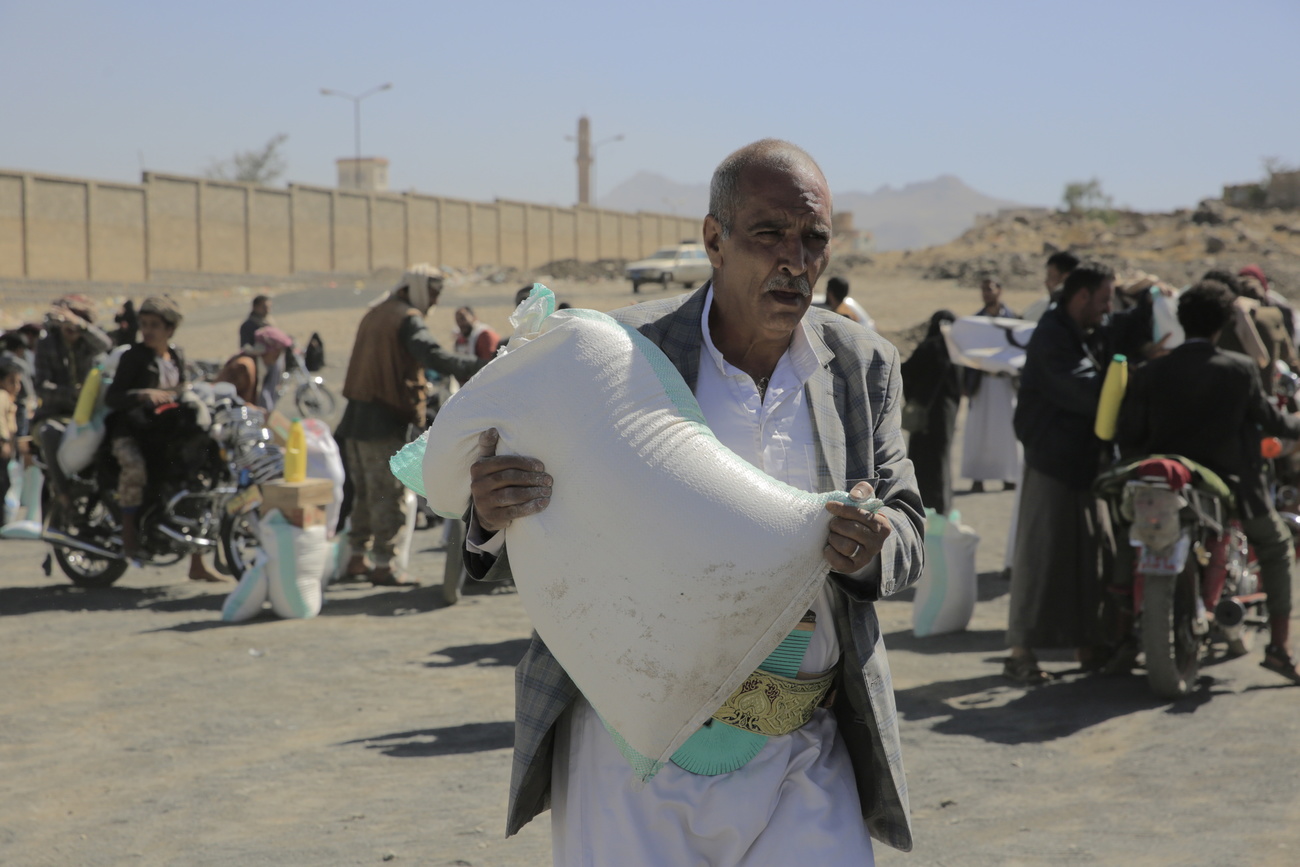 Un uomo porta un sacco di cibo nello Yemen