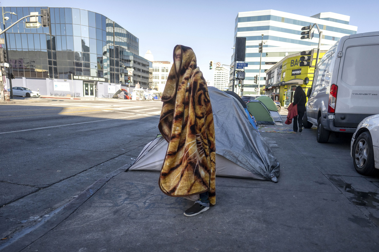 senzatetto in piedi avvolto da una coperta. il suo volto non si vede. los angeles