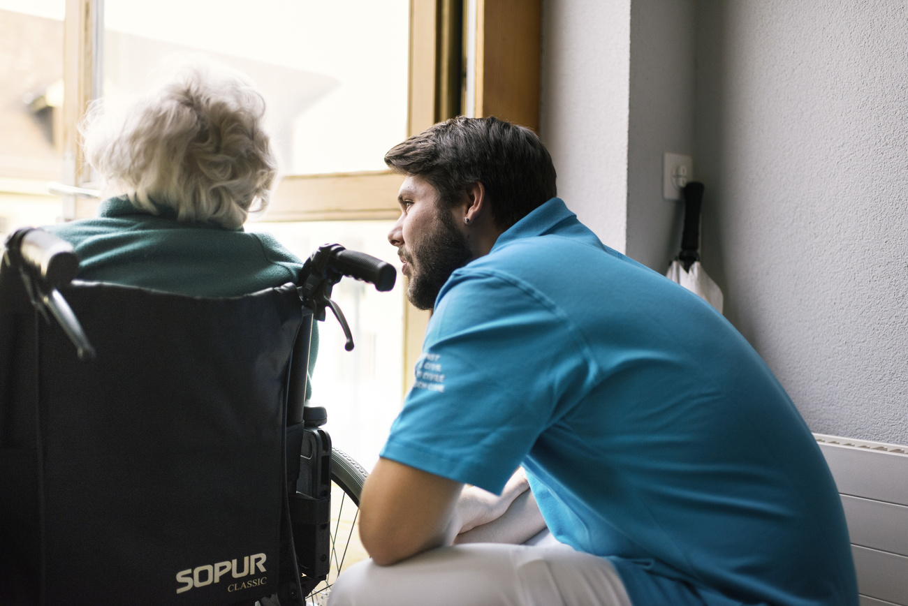 elderly lady in wheelchair with carer