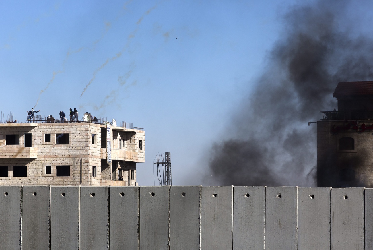 Israel separation wall with tear gas smoke