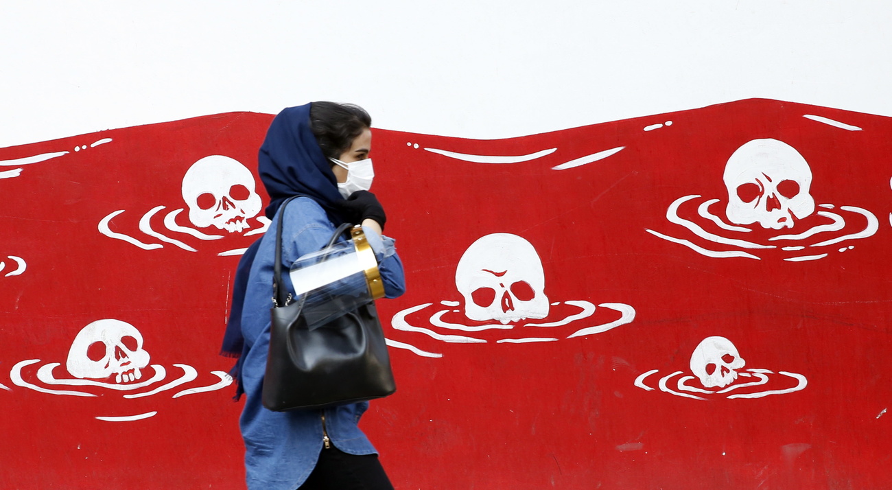 woman walking past anti-US all painting in Tehran