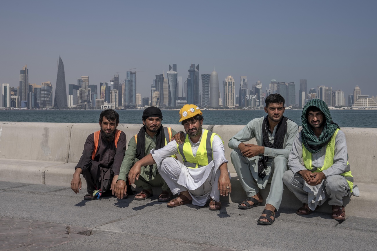 lavoratori seduti su un marciapiede. dietro di loro skyline di grattacieli