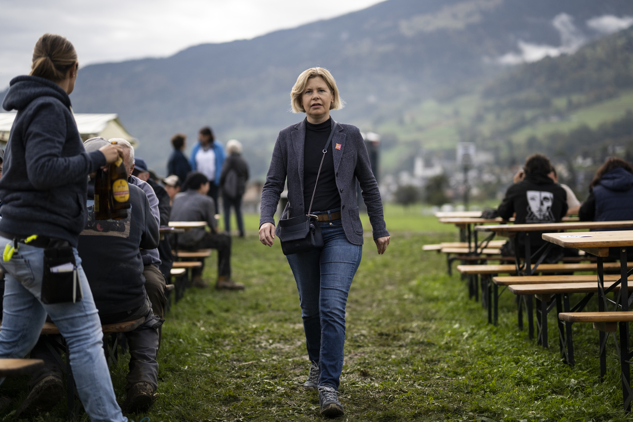 Donna cammina tra tavoli all aperto.
