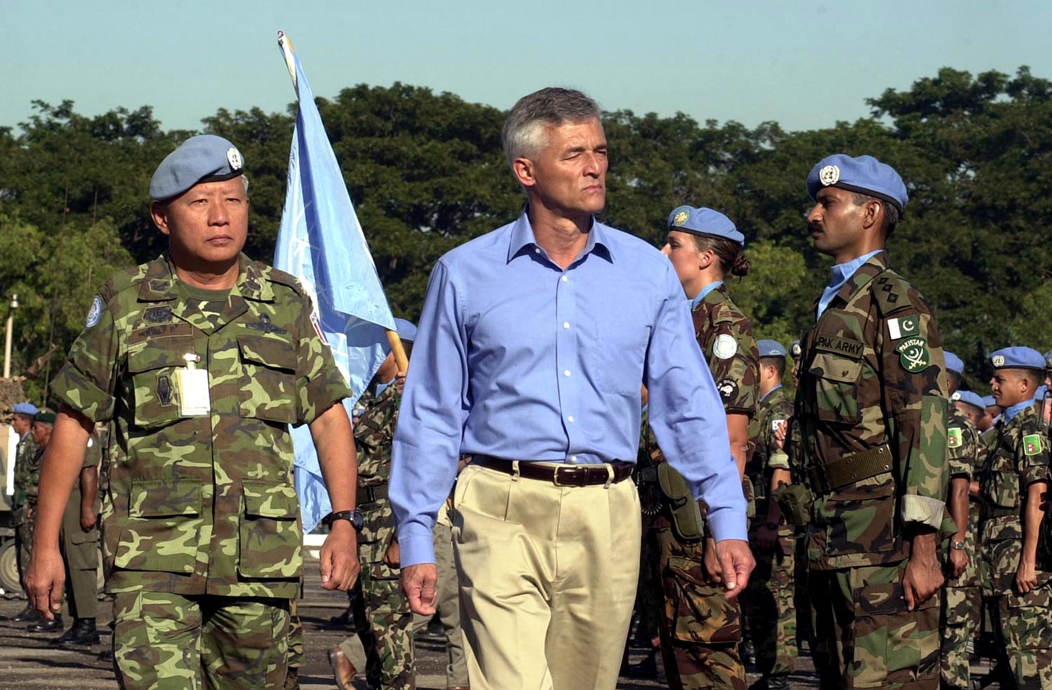 Homme en civil passant des bérets bleus de l ONU en revue