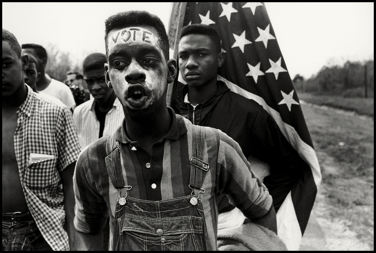 Un joven americano de ascendencia africana protestante con la palabra vota en su frente