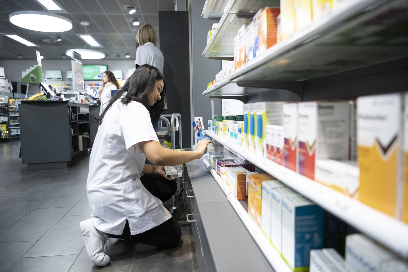 pharmacienne devant un rayon de médicaments