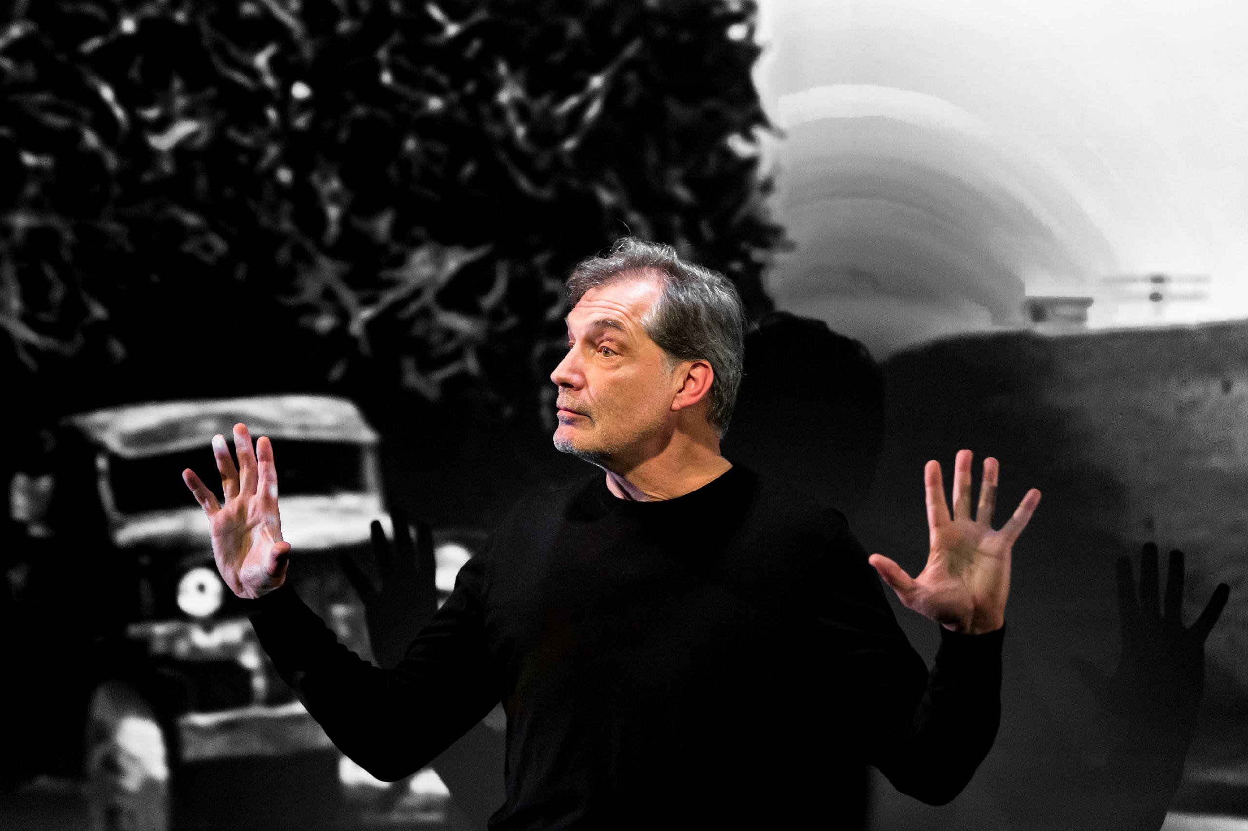 Der Schauspieler Samuel Labarthe auf der Bühne vor einem von Nicolas Bouvier aufgenommenen Foto