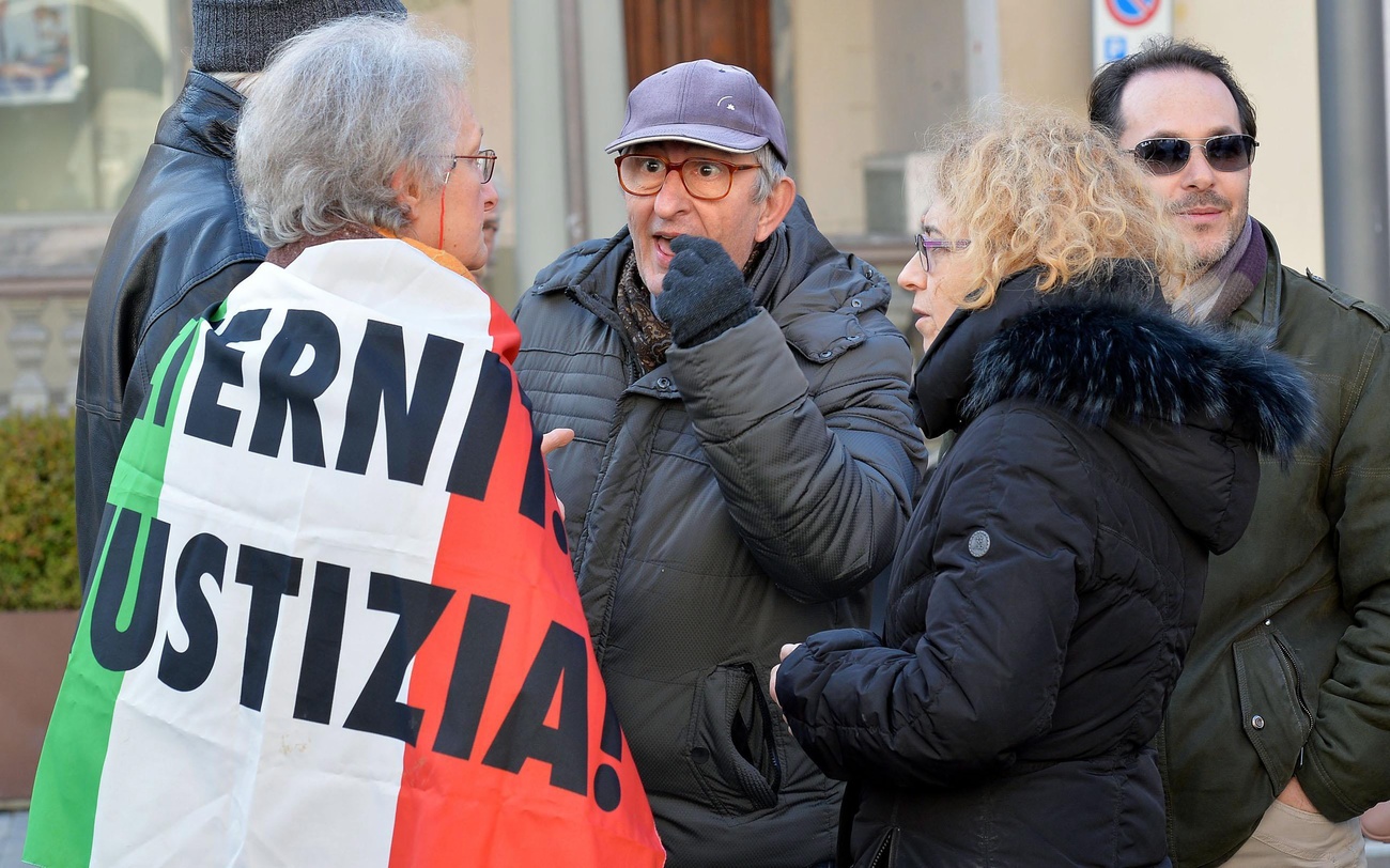 Pessoas com bandeira italiana esperando fora do tribunal