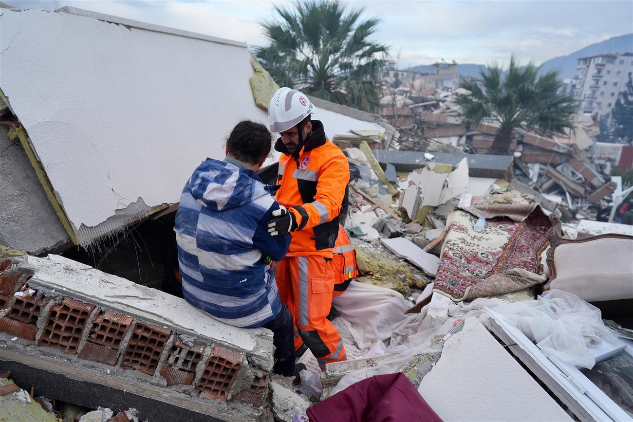 soccorritore assieme a una persona su un cumulo di macerie