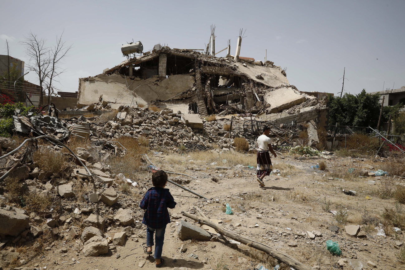 Enfant regardant des bâtiments détruits au Yémen