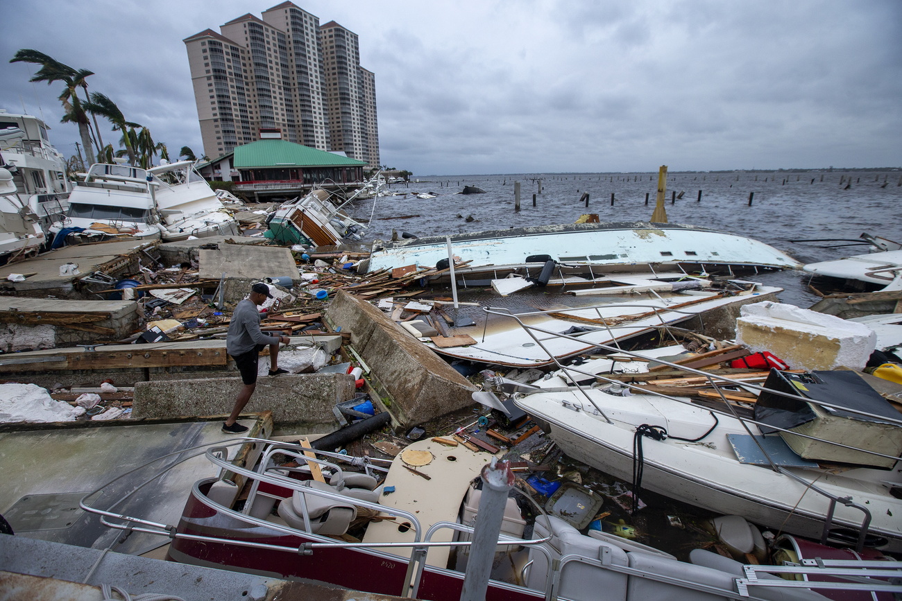 As pessoas olham em barcos destruídos na Flórida