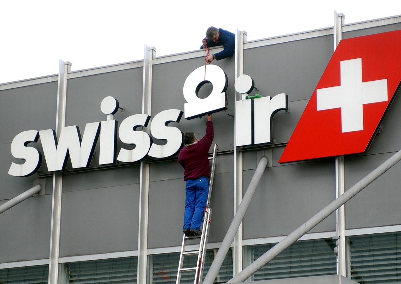 Operai tolgono il logo di Swissair dal terminale A dell aeroporto di Zurigo.