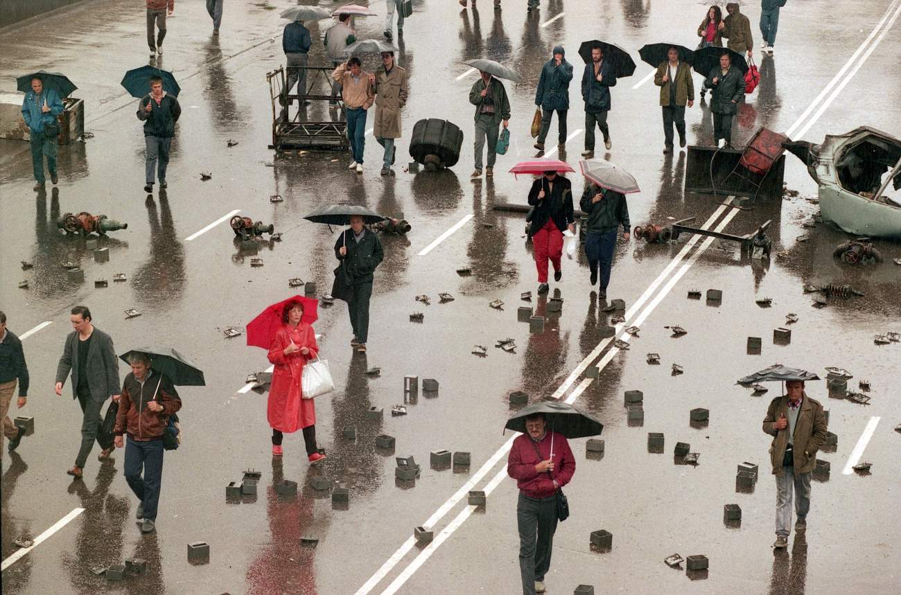 Personnes avec des parapluies dans une rue marquée par des manifestations