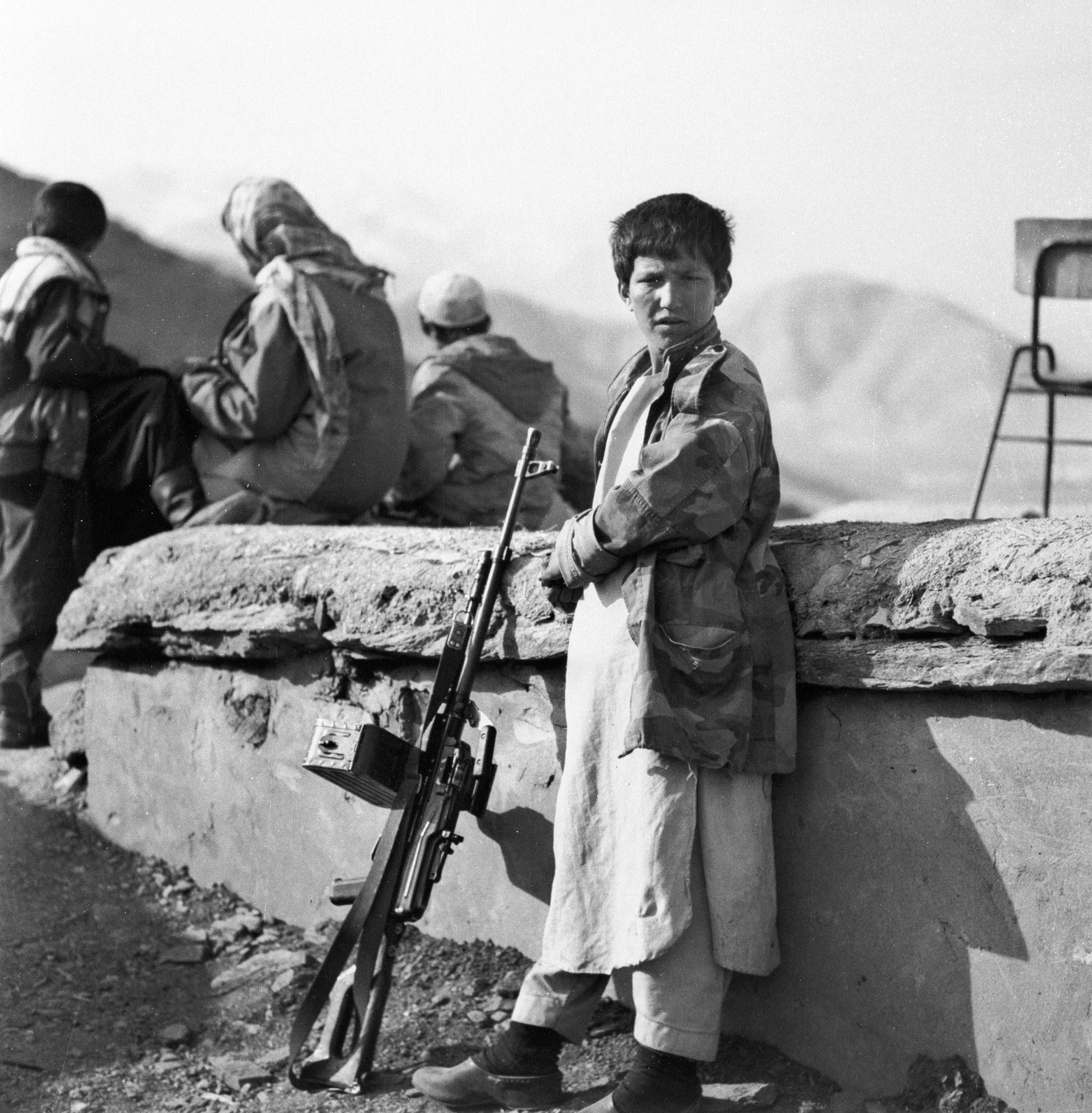 A black and white photo of a child soldier in Afghanistan