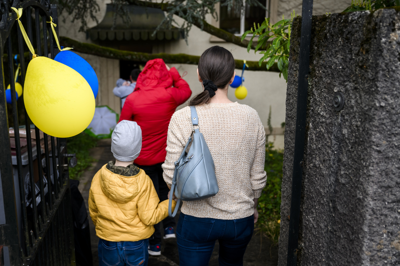 madre e figlio che si passano un palloncino giallo e blu