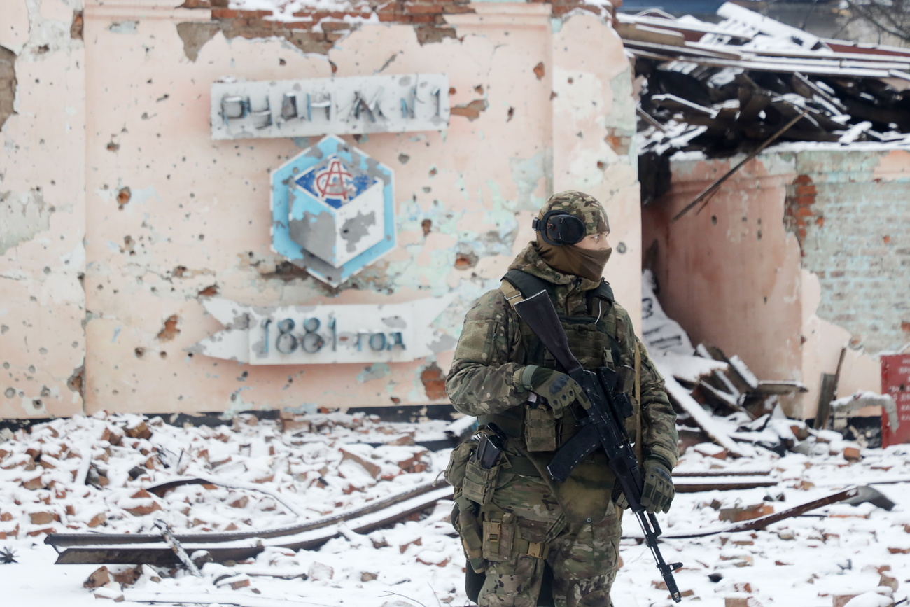 2023年1月29日，在頓涅茨克北部戰火紛飛的索萊達鎮，一名瓦格納集團的戰士站在一棟被猛烈炮火摧毀的建築前。