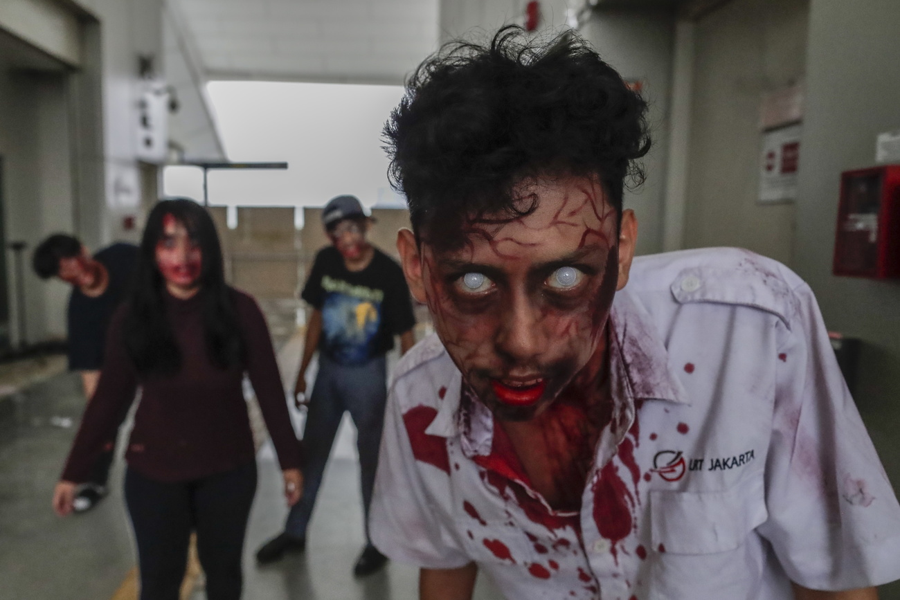 Mann, als Zombie geschminkt: mit weissen Augen und blutigem Mund und blutigem Hemd