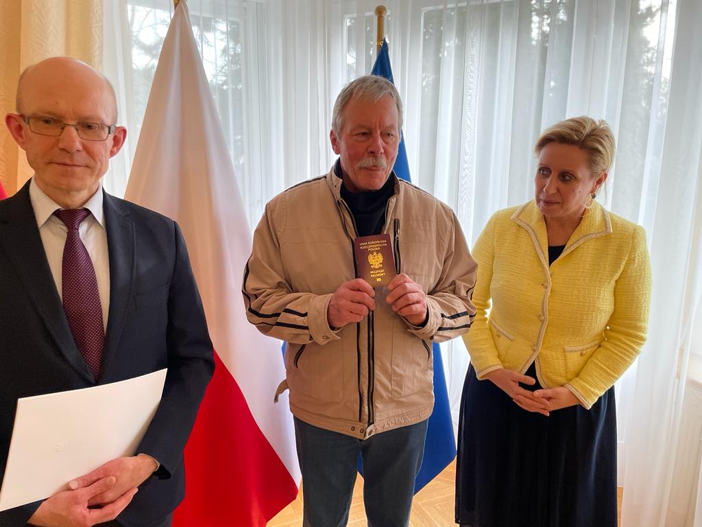 Deux hommes et une femme lors de la remise d un passeport.