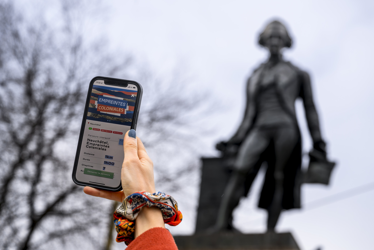 A mobile phone gives an explanation of the colonial statues tour.