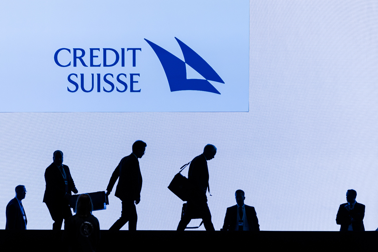 sagome di persone in controluce sotto il logo di credit suisse