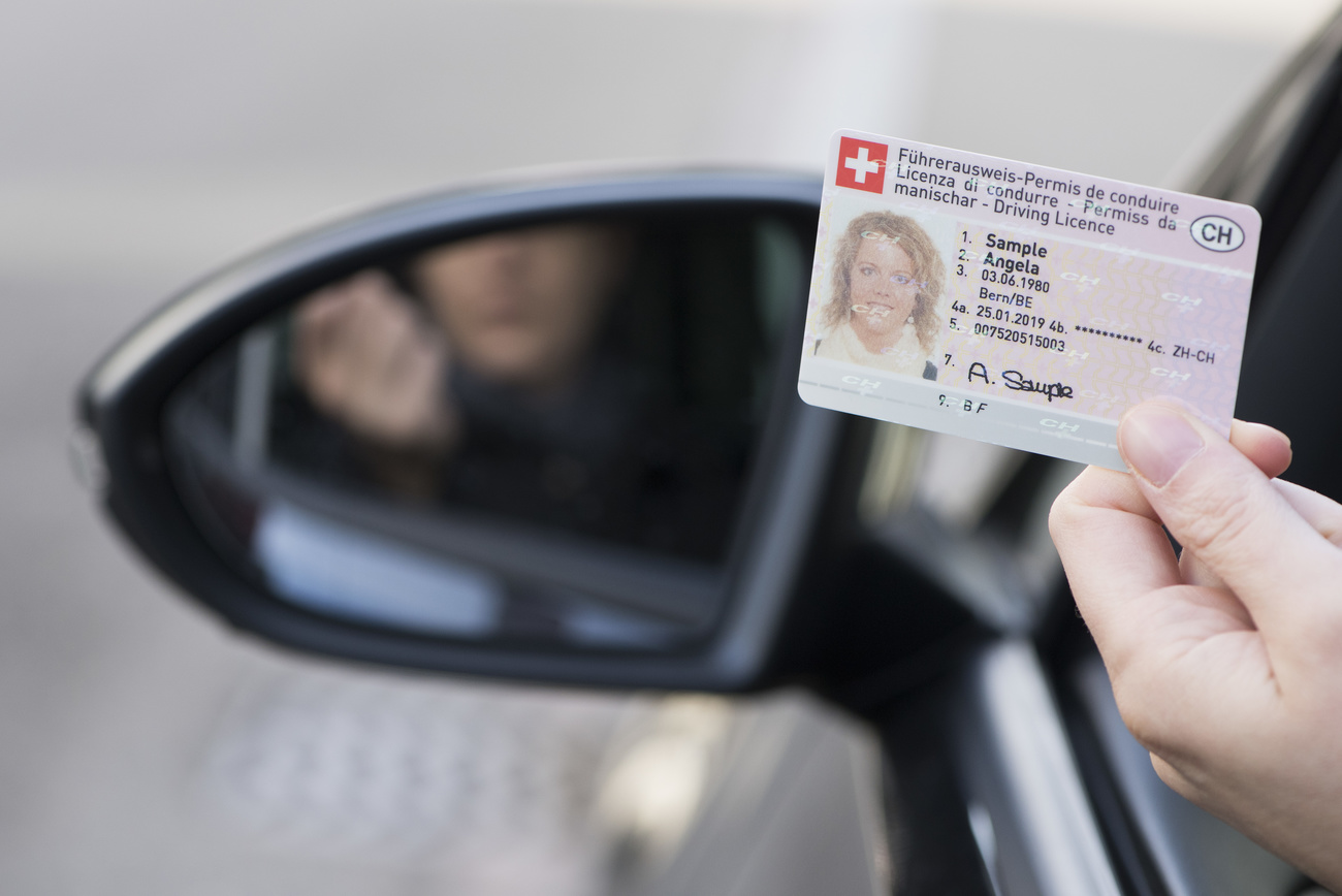 Permis de conduire dans une main devant un rétroviseur